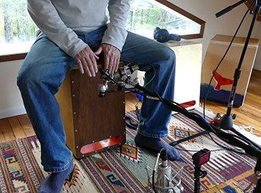 Recording audio and video of a cajon player in a home studio.